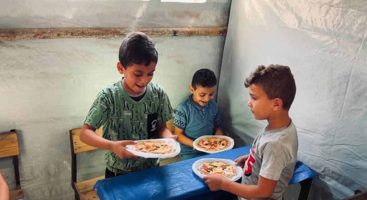 Students at Al Ansar School in north Gaza receiving pizza